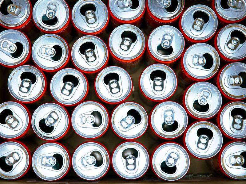 Empty aluminum beverage cans packed upright in a cardboard box, seen from above