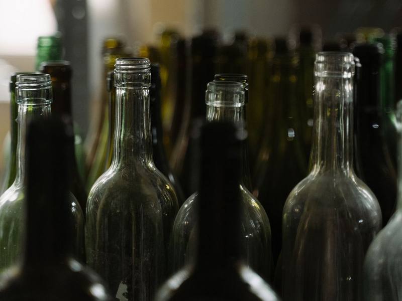 Empty green and clear wine bottles standing in rows